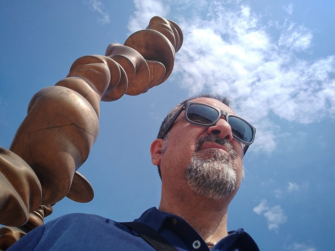 Denis Spedalieri, la “Guida Inutile New York” davanti allo Stadio Grande Torino insieme ad una colonna di Tony Cragg